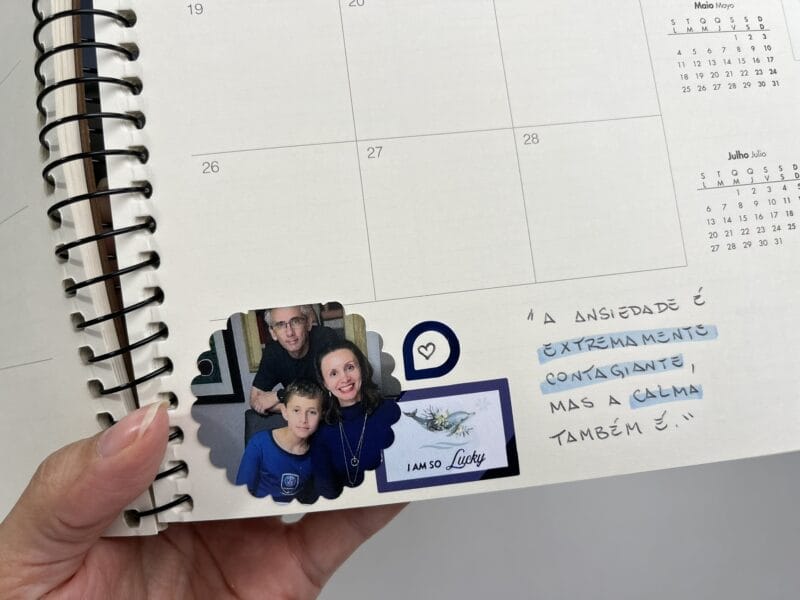 Planner 2026 aberto com frase inspiradora escrita à mão e detalhes em marca-texto colorido.